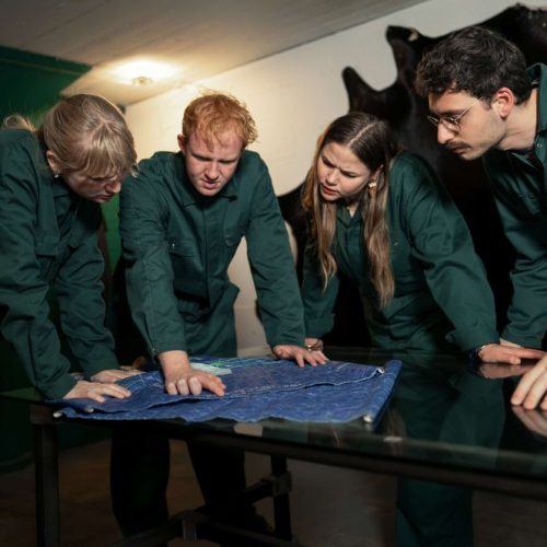 Team in overalls studying a blueprint in an escape room in Utrecht in English