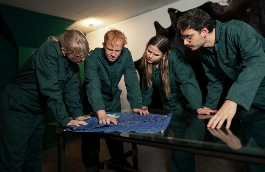 Team in overalls studying a blueprint in an escape room in Utrecht in English
