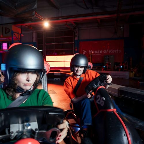 Twee deelnemers met helm in de driftkarts van Fusion Drift Utrecht