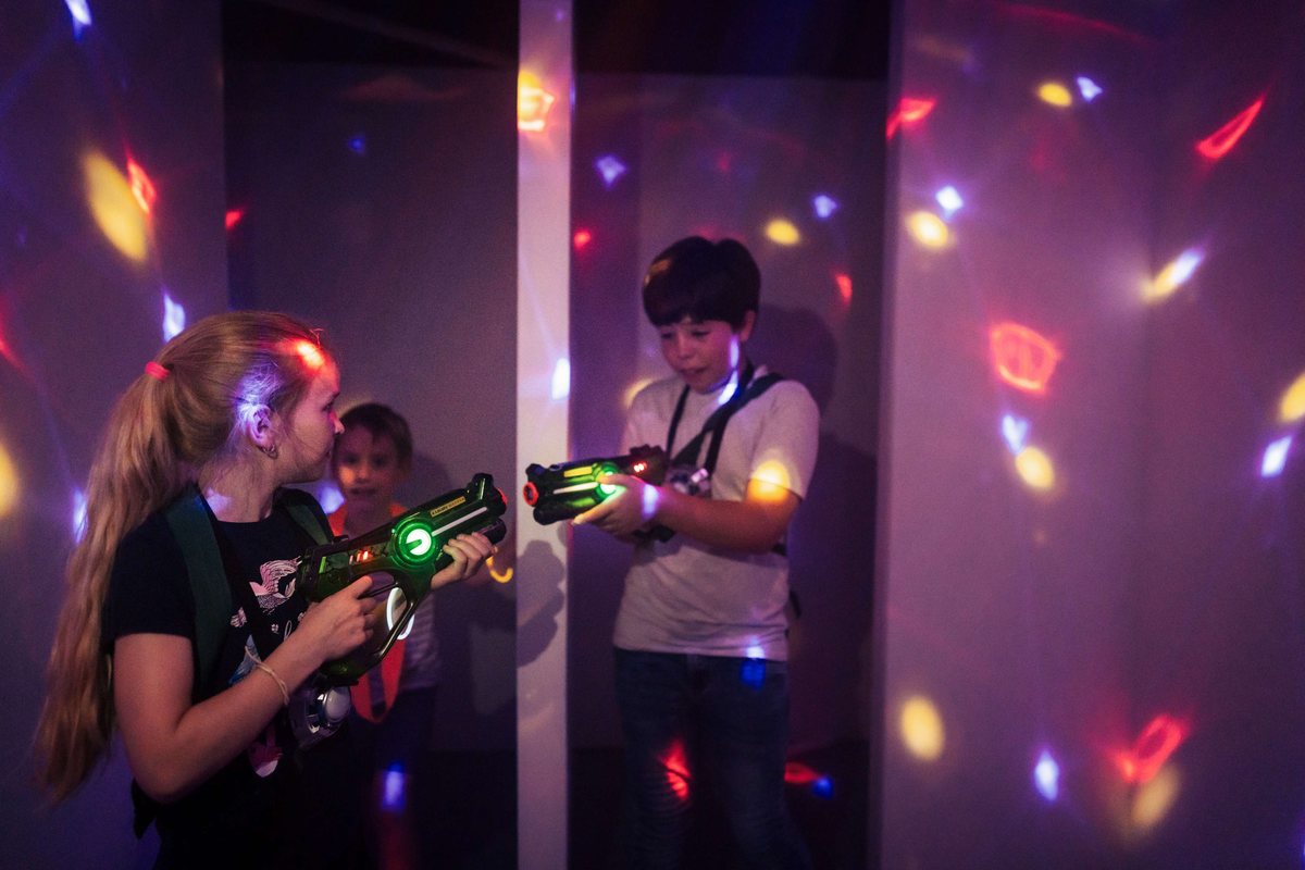 Twee kinderen zoeken dekking achter een wand in het lasergame-doolhof