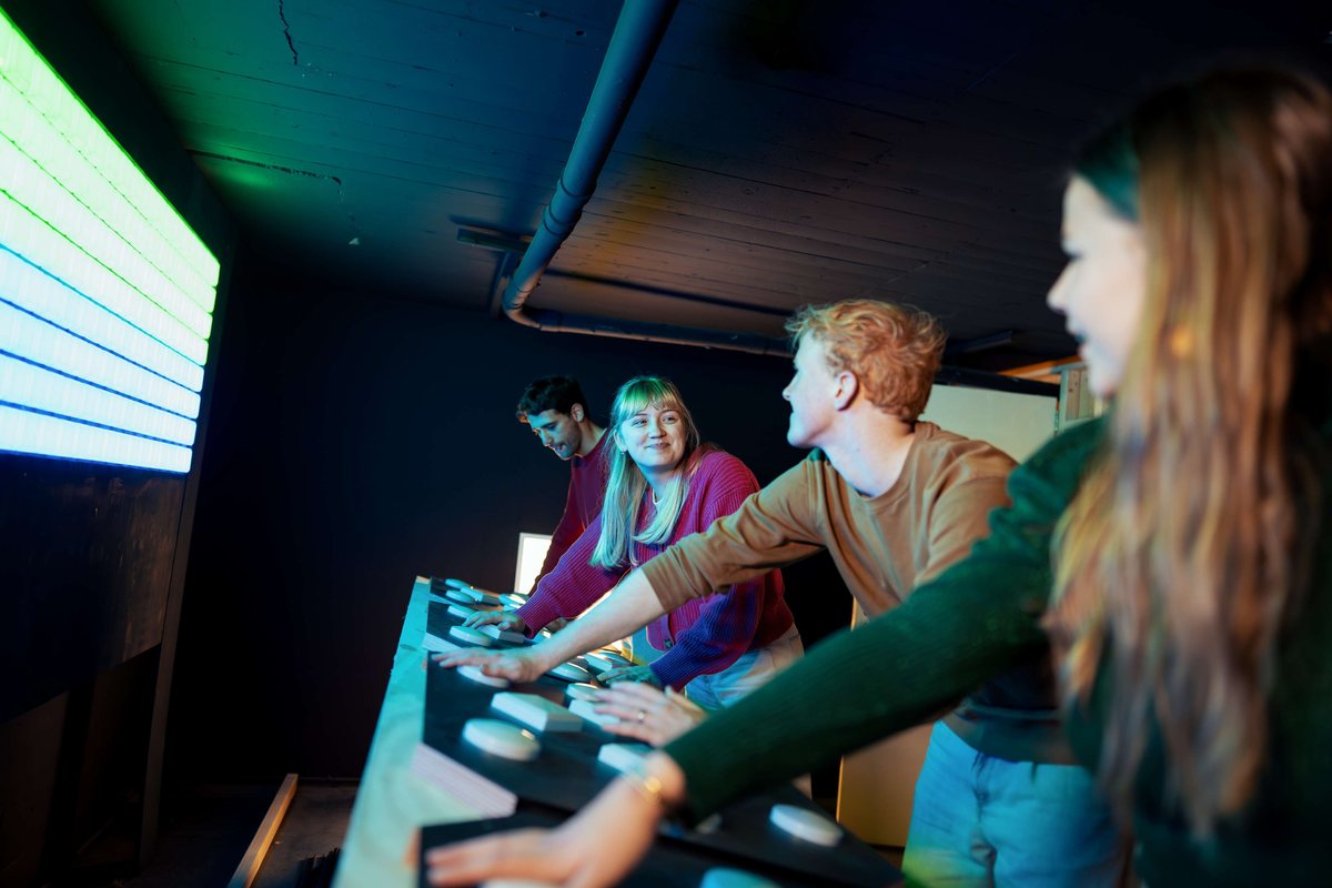 International team hitting illuminated buttons during the HIT social game in Utrecht