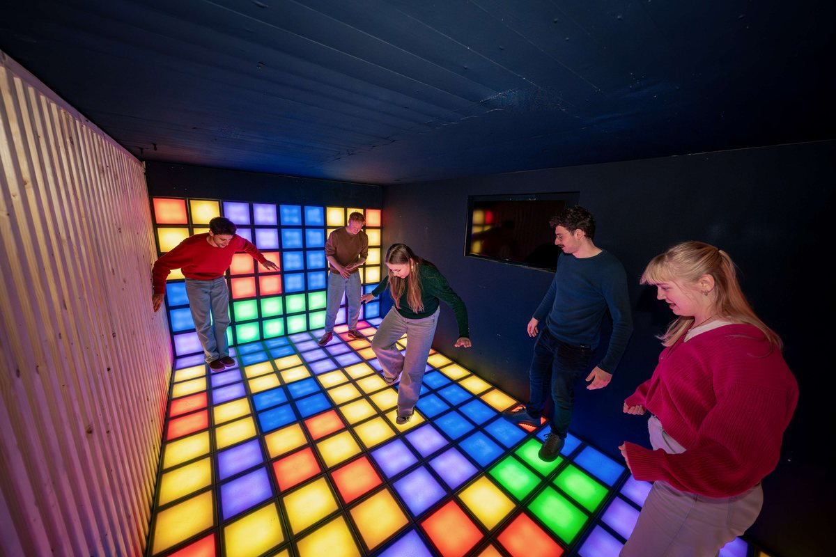 Collega's spelen samen op de lichtgevende vloer van de social games