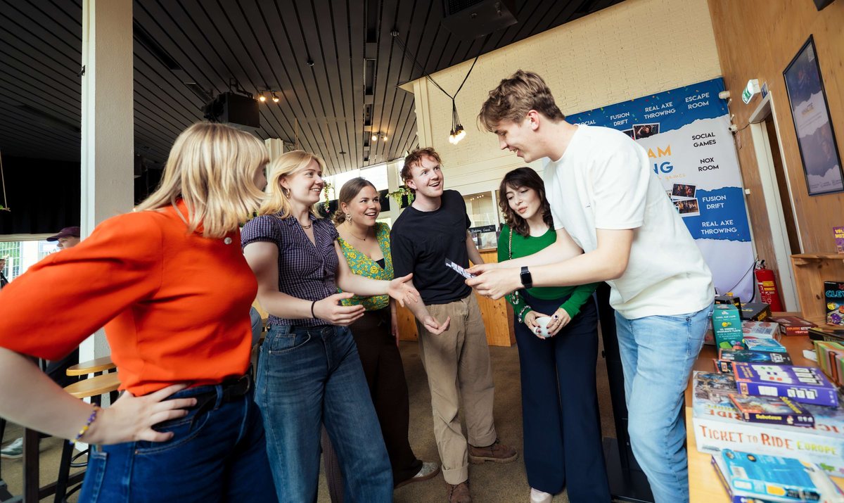 Groep kiest een bordspel in de lounge van The Team Building