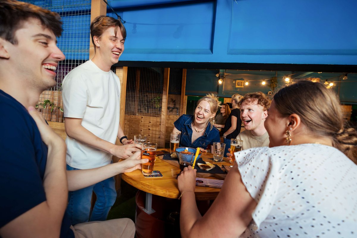 Vriendengroep proost aan de statafel bij de axe throwing banen in Utrecht