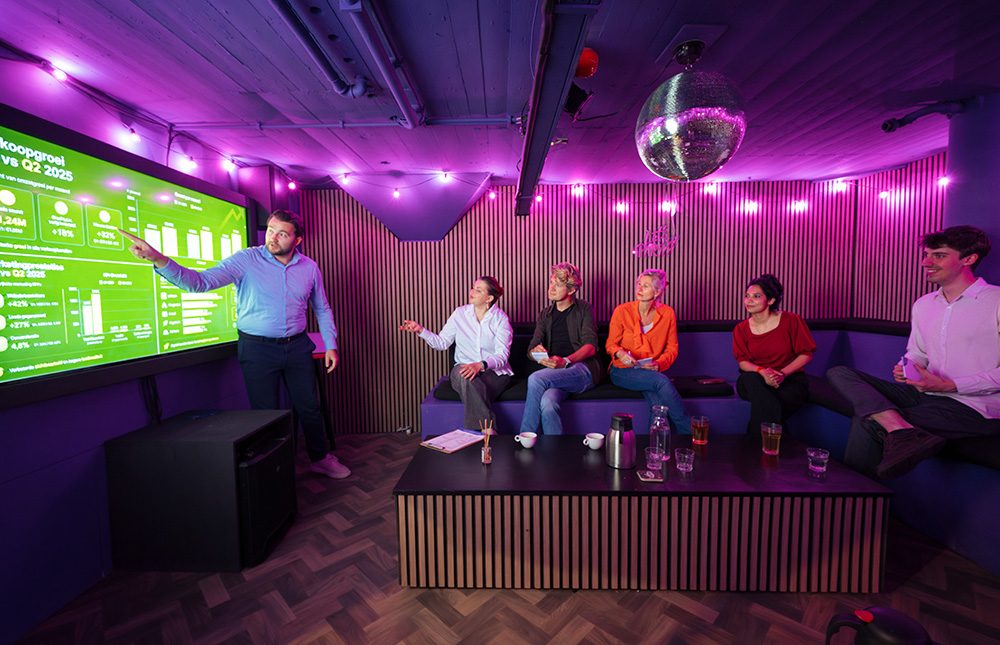 Vergaderen in de Melody Room van The Team Building met een presentatie op het scherm